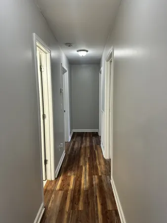 a view of a hallway with wooden floor