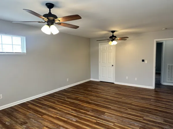 a view of an empty room with a chandelier fan