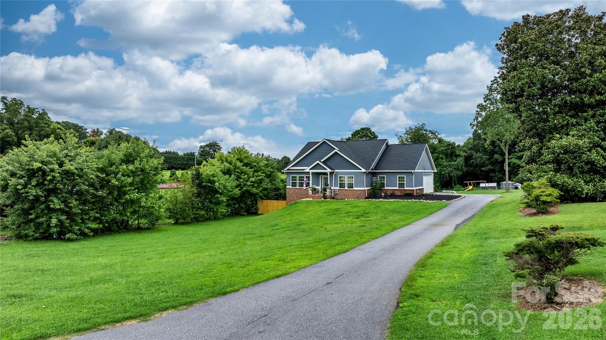 111 Pinewood Road Granite Falls, NC 28630 - Photo 2 of 33 a view of a big house with a big yard and potted plants in front of the house