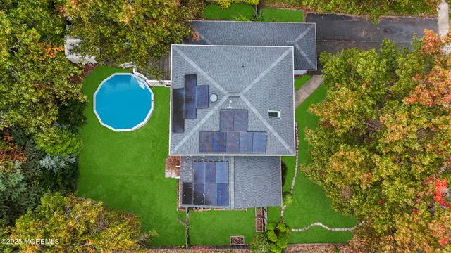 an aerial view of a house with a swimming pool and garden