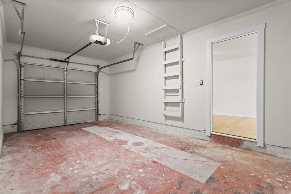 907 Pinson Road Forney, TX 75126 - Photo 25 of 35 Garage interior featuring a sectional garage door, overhead lighting, and an automatic garage door opener