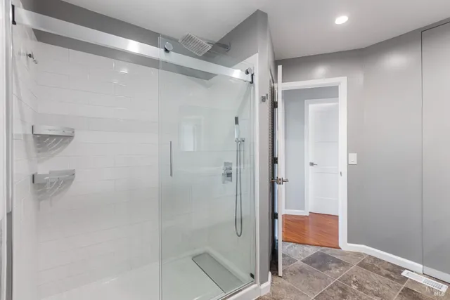 a bathroom with a shower and a glass door