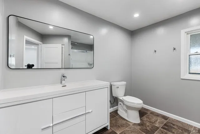 a bathroom with a toilet sink and mirror