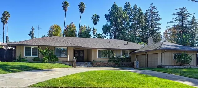 a view of a house with a yard and potted plants