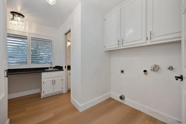 a kitchen with granite countertop a sink and a white wooden floor