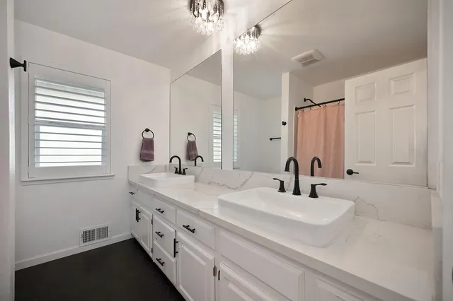 a bedroom with a large bed a chandelier and a couch