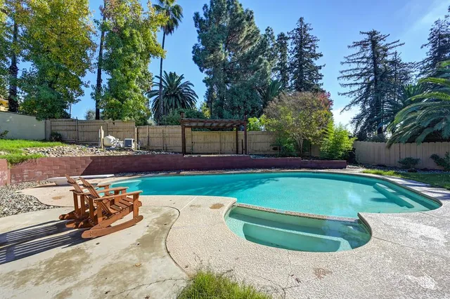 a view of backyard with swimming pool and outdoor seating