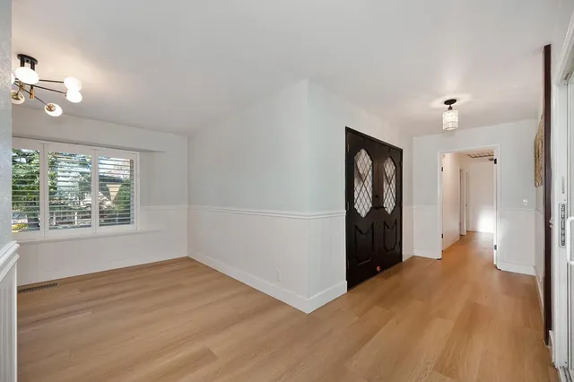 a view of a hallway with wooden floor and cabinet