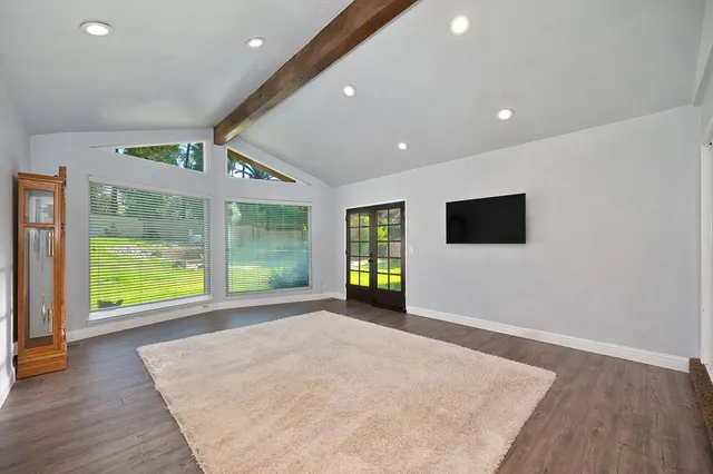 a dining room with furniture potted plants and wooden floor