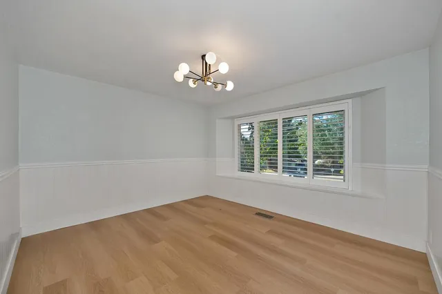 a view of a room with wooden floor and a ceiling fan