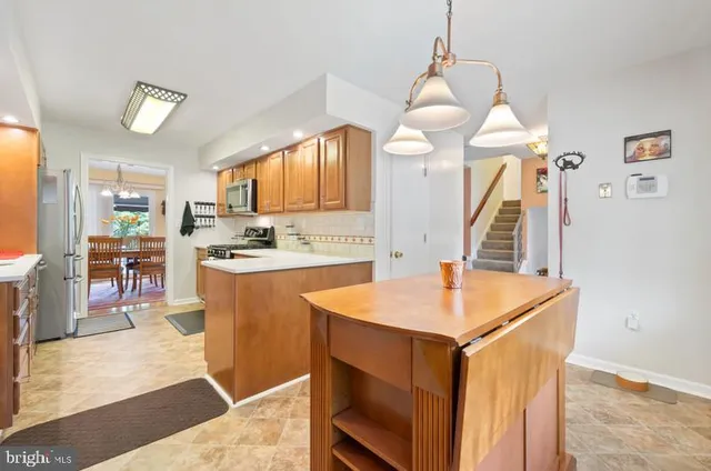a kitchen with stainless steel appliances kitchen island granite countertop a sink a stove and a refrigerator