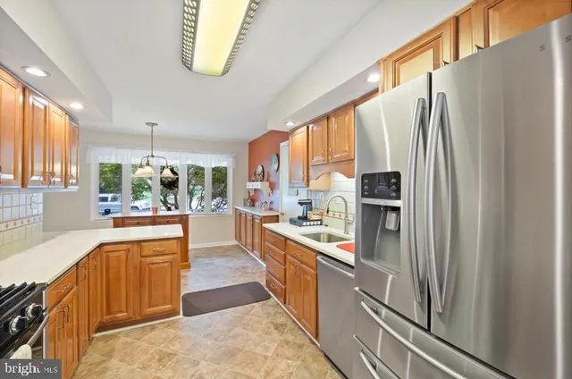 a kitchen with stainless steel appliances granite countertop a refrigerator a sink and a stove