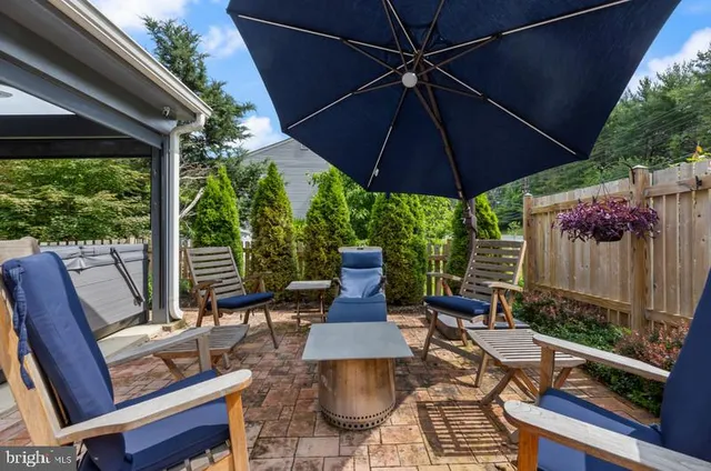 a view of a patio with table and chairs under an umbrella