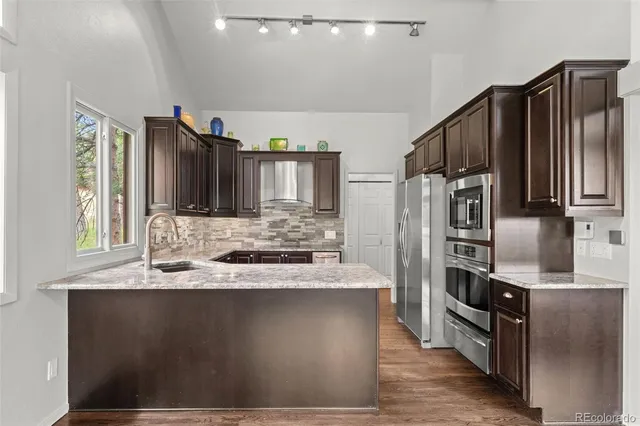 a kitchen with kitchen island granite countertop a sink cabinets and stainless steel appliances