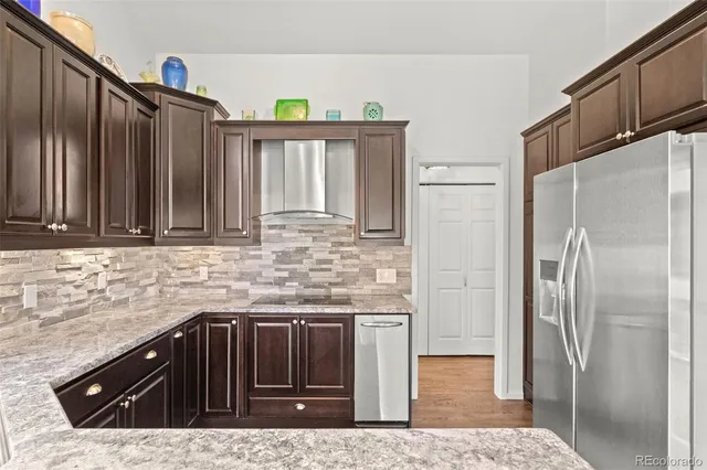 a kitchen with granite countertop a refrigerator and a sink