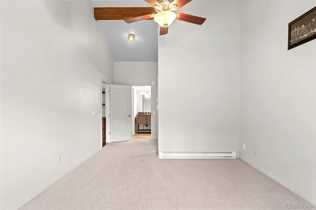 an empty room with a fan & a ceiling fan