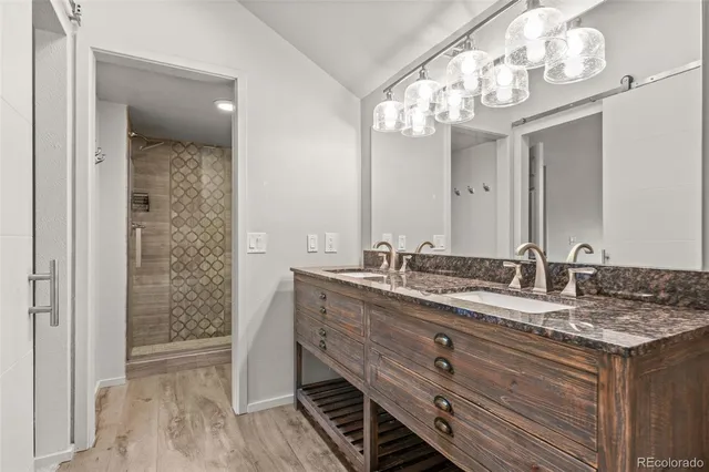 a bathroom with a granite countertop sink a large mirror and a shower