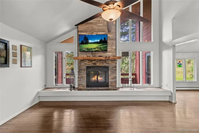 a view of a livingroom with fireplace wooden floor and windows
