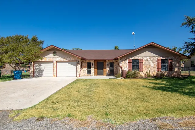 a front view of a house with a garden and yard