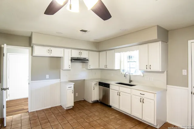 a kitchen with a sink window and cabinets