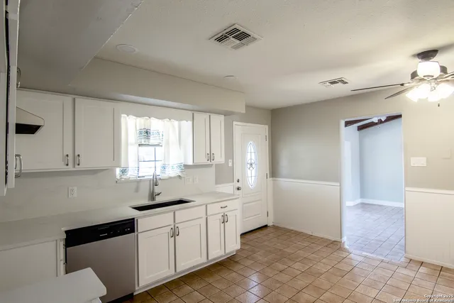 a kitchen with a sink window and cabinets