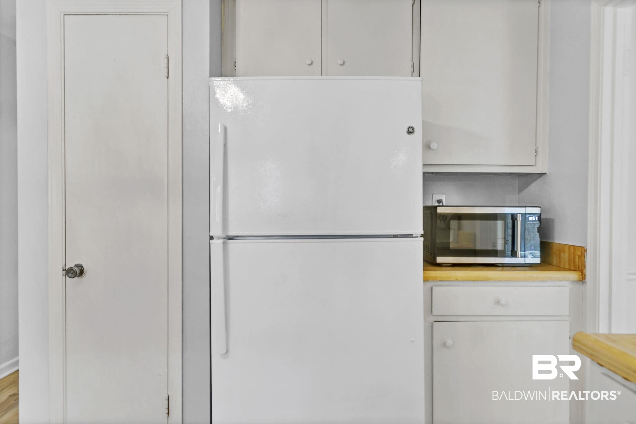 5817 Woodgate Road Mobile, AL 36609 - Photo 27 of 85 Kitchen featuring freestanding refrigerator, stainless steel microwave, and white cabinetry