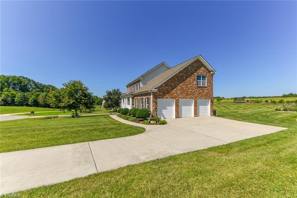 3403 Garrick Trace Browns Summit, NC 27214 - Photo 2 of 49 Side of Home with 3-Car Garage