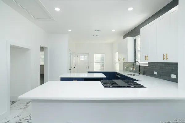 a large white kitchen with a large window