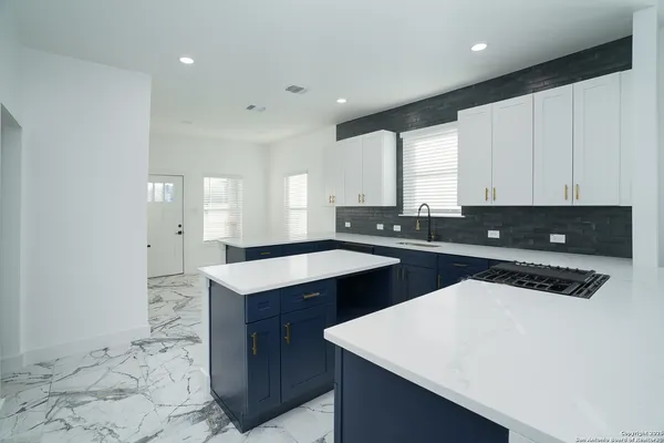 a kitchen with a sink a stove and cabinets