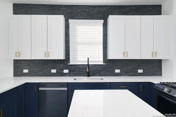 a kitchen with granite countertop a sink a stove and cabinets