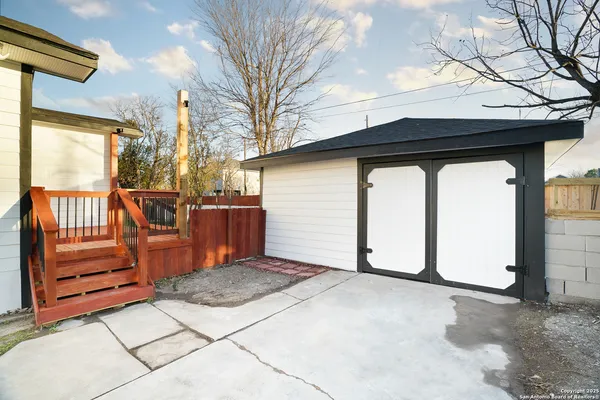 a view of backyard with wooden fence