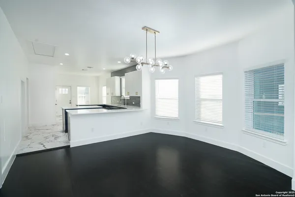 a view of a kitchen with wooden floor and a window