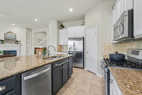 a kitchen with stainless steel appliances granite countertop a sink stove and refrigerator