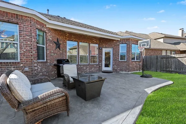 a view of a patio with couches chairs and wooden fence