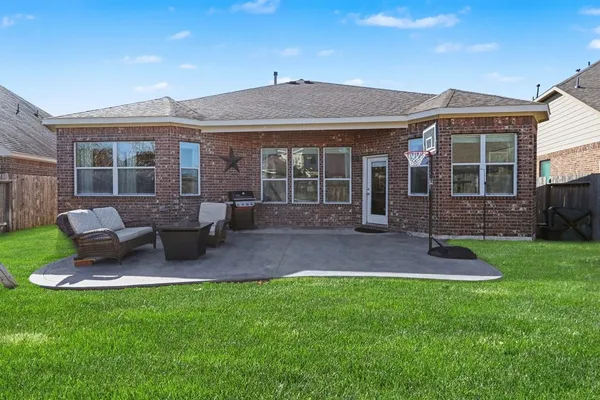 a view of a house with a yard and furniture