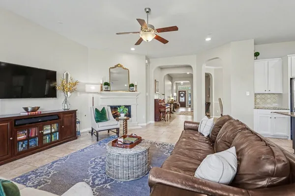a living room with furniture a flat screen tv and a fireplace