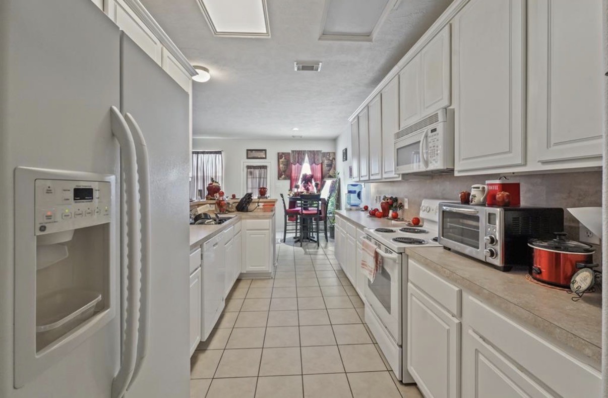 13134 Peppergate Lane Houston, TX 77044 - Photo 11 of 23 a kitchen with stainless steel appliances kitchen island granite countertop lots of counter top space and cabinets
