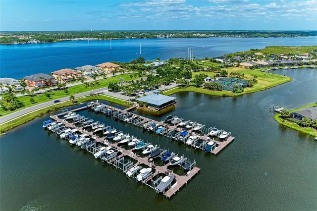 an aerial view of ocean and residential houses with outdoor space
