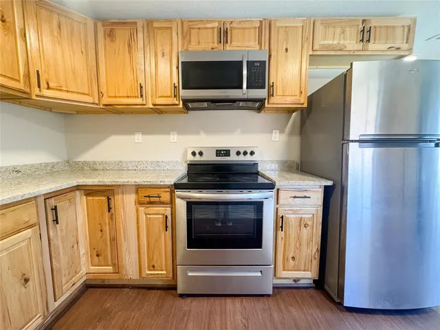 a kitchen with stainless steel appliances granite countertop a refrigerator stove and microwave