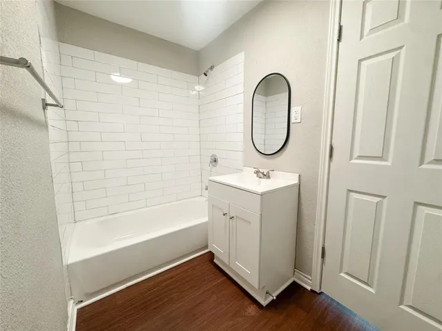 a bathroom with a double vanity sink mirror and bathtub
