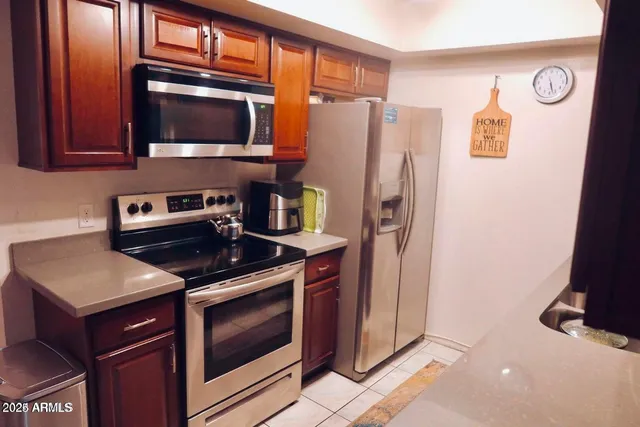 a kitchen with stainless steel appliances granite countertop a refrigerator stove and microwave