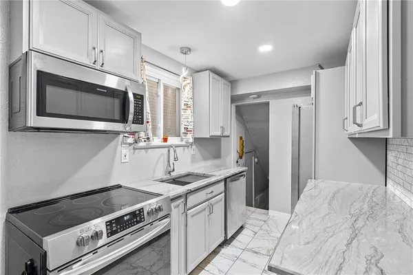 a kitchen with stainless steel appliances a stove a microwave and a refrigerator