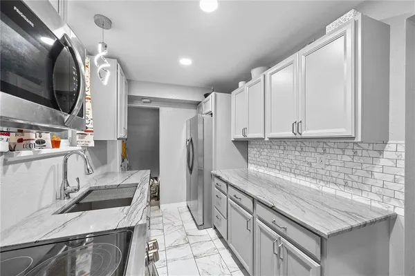 a kitchen with stainless steel appliances granite countertop a sink stove and refrigerator