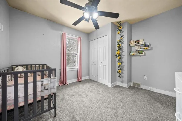 a view of an empty room with a window and a ceiling fan