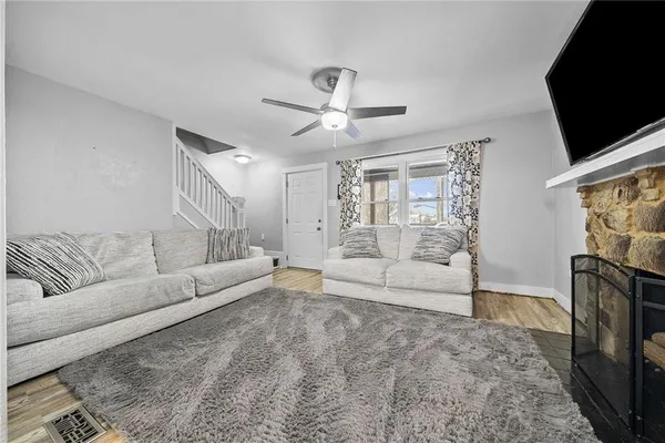 a living room with furniture a flat screen tv and a fireplace