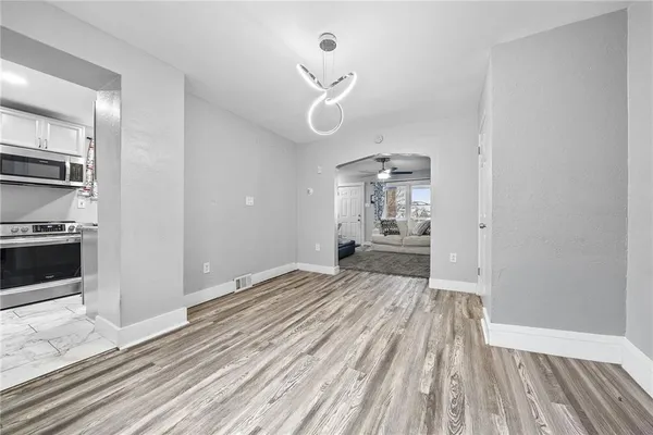 a bedroom with wooden floor closet and windows