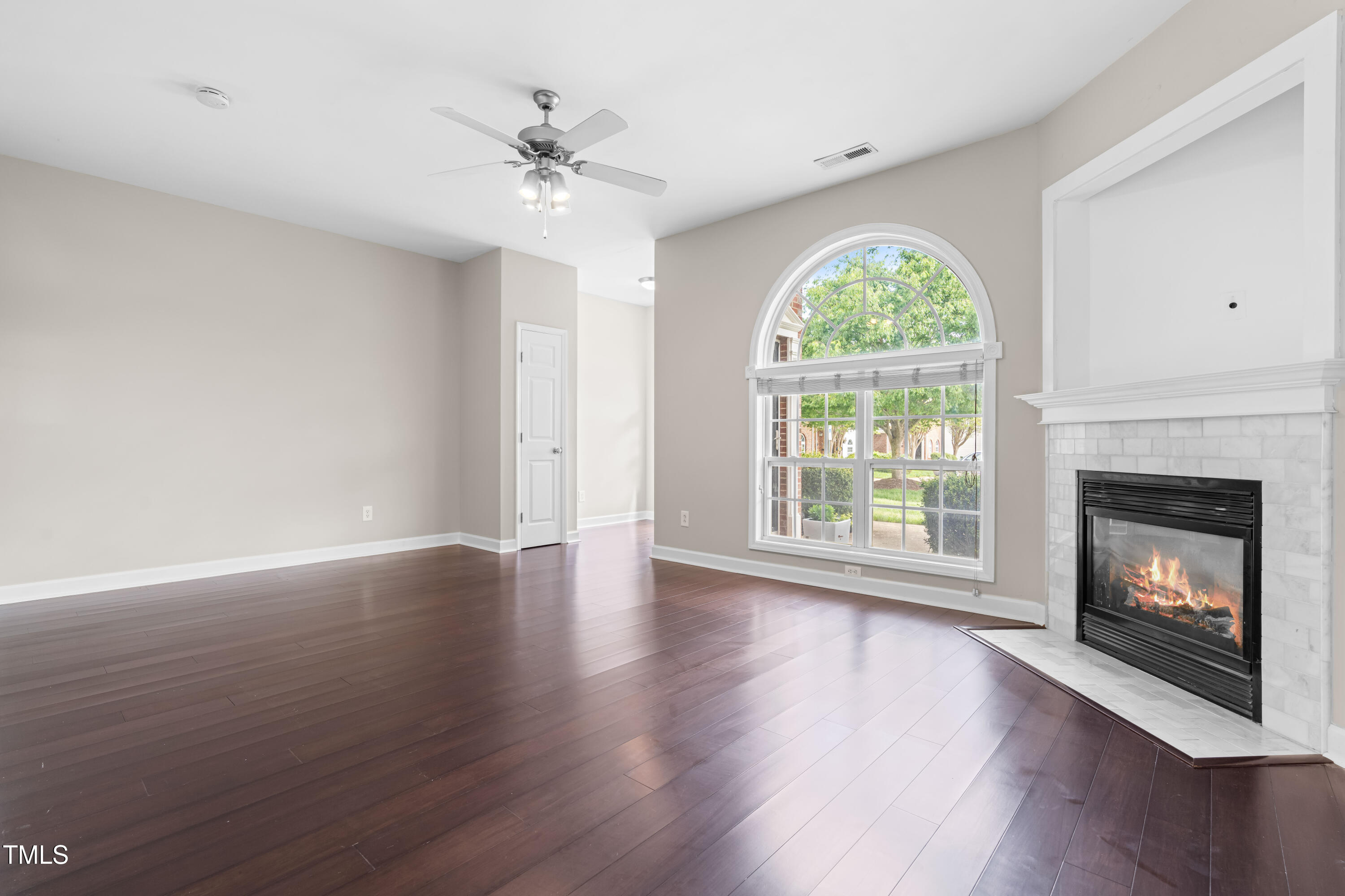 2101 Piney Brook Road, Unit 105 Raleigh, NC 27614 - Photo 4 of 24 a view of an empty room with wooden floor fireplace and a window
