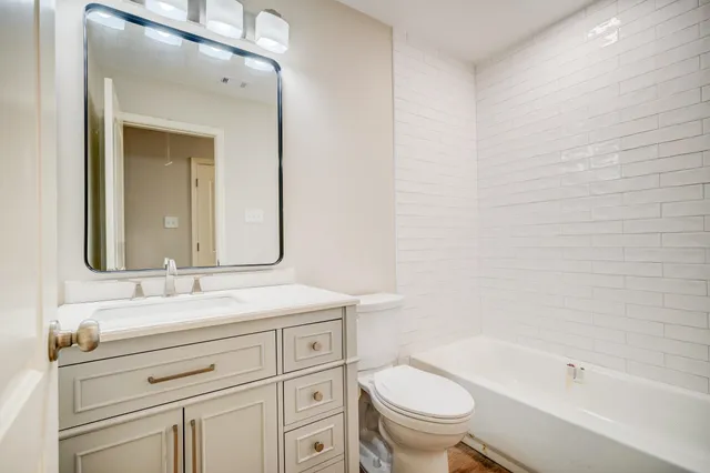 a bathroom with a granite countertop toilet a sink and a bathtub