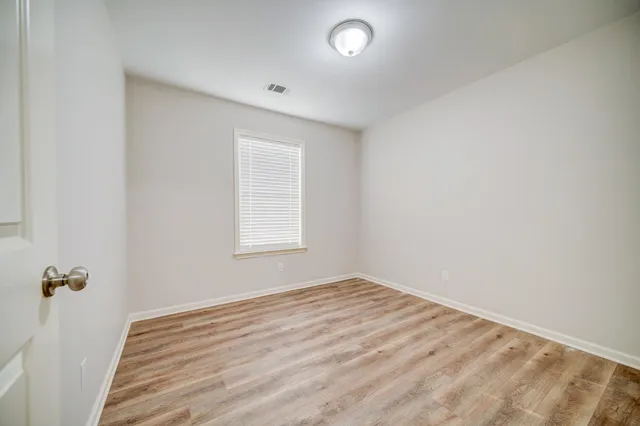 an empty room with a white cabinet and a window
