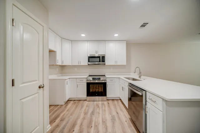 a kitchen with stainless steel appliances granite countertop a sink stove and refrigerator